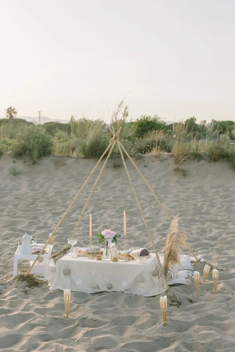 A styled low table set on the sand with candles and flowers — an Australian beach Christmas lunch