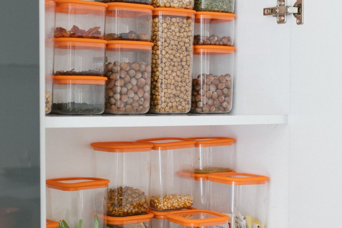 Clear plastic storage containers with lids stacked neatly in a pantry — the kind of storage buy this Kmart, Target and Big W comparison is about