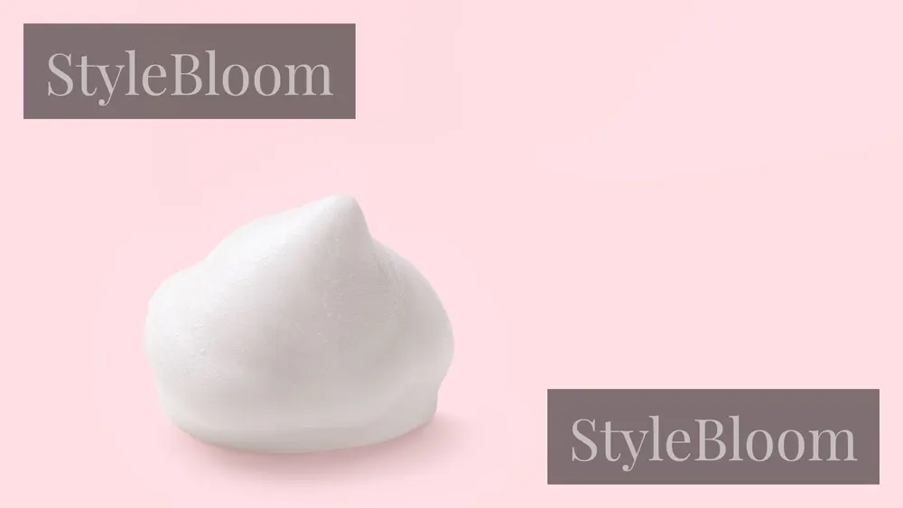 A dollop of white mousse foam on a pink background