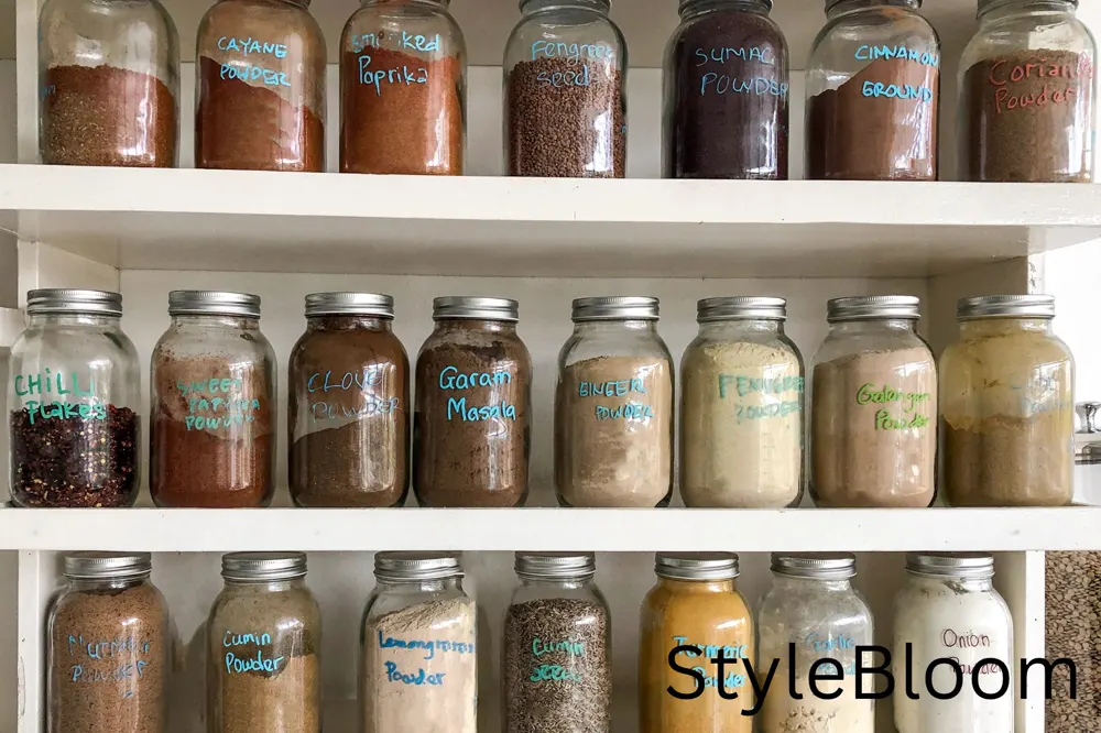 Labeled glass spice jars on pantry shelves