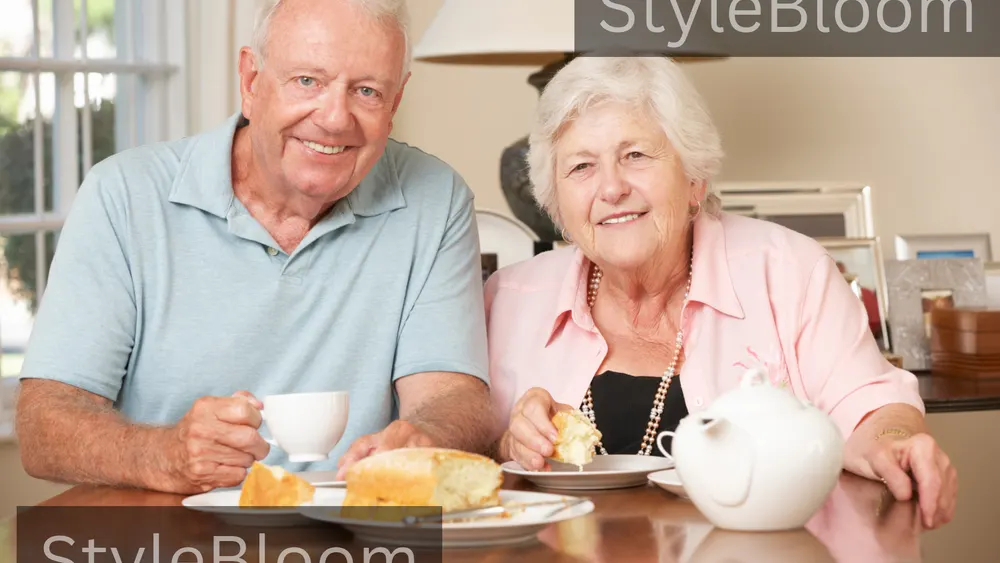 A senior couple sharing afternoon tea at a table, with a white teapot and cake on plates