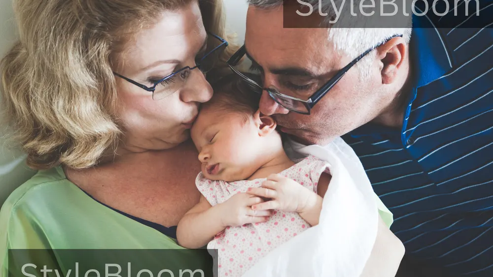 Two older adults holding a sleeping newborn in soft light