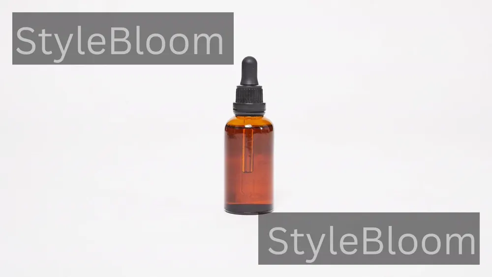 An oil bottle and dropper on a plain neutral background