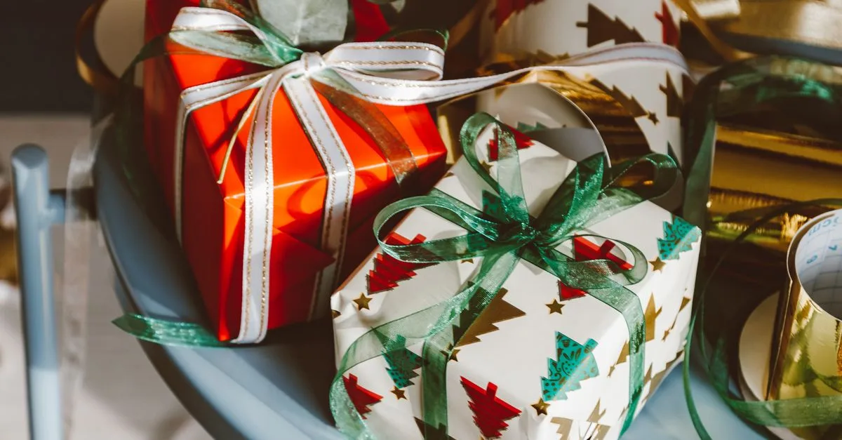 Small Christmas gifts wrapped in festive paper and tied with satin ribbon — stocking stuffers for mom